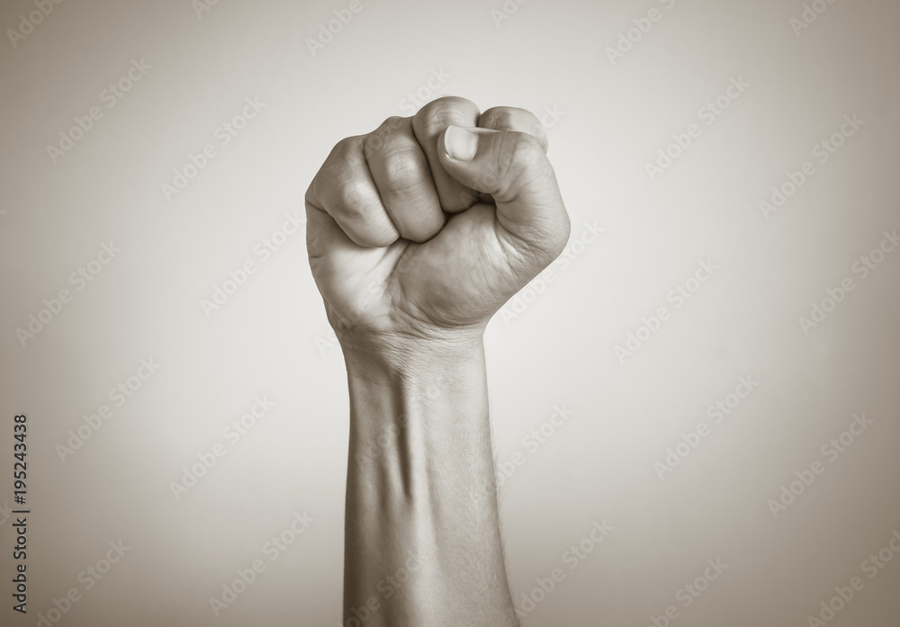 Closeup of fist clenched in the air. Power, victory, revolution concept.